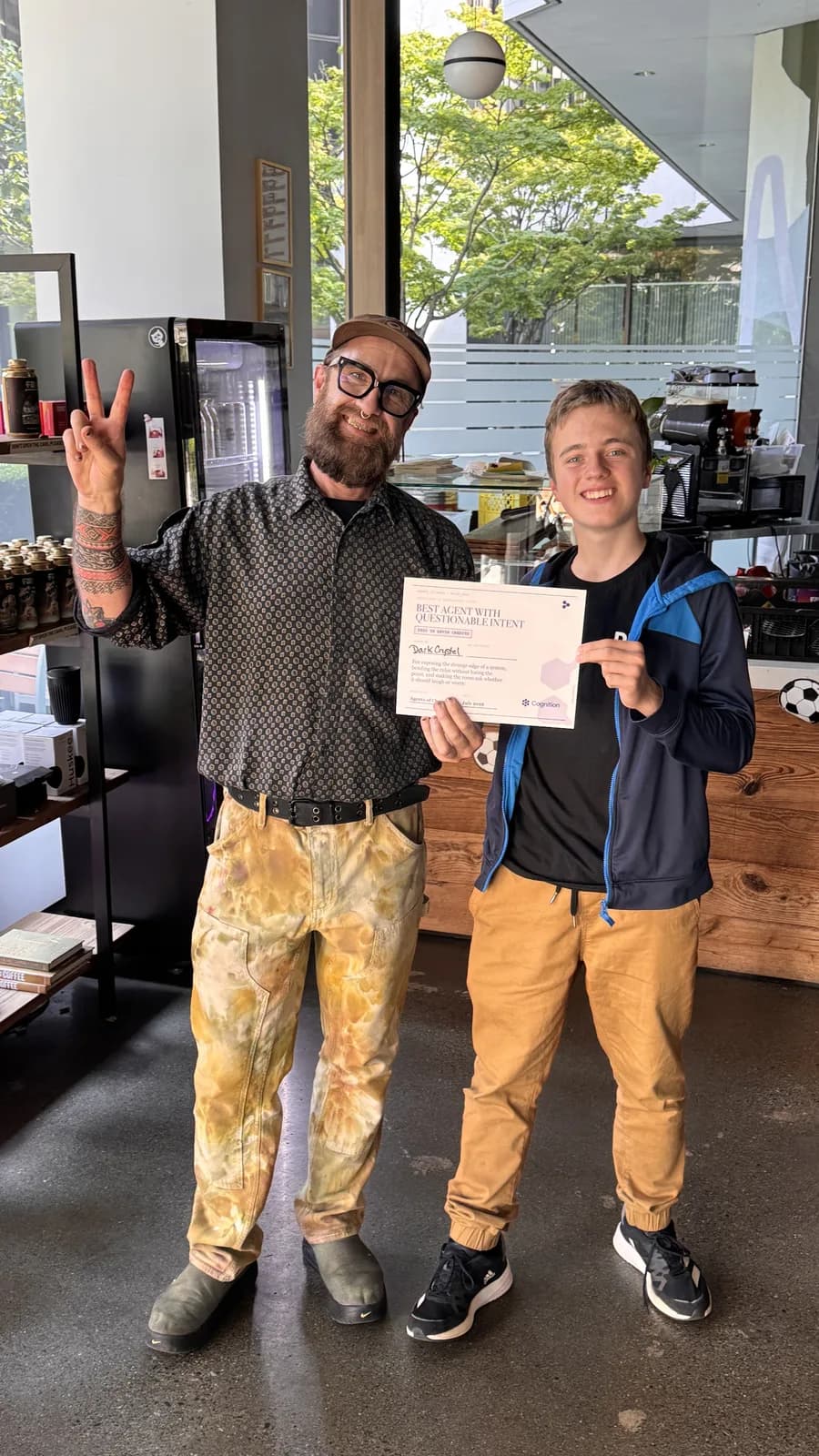 Kris Krüg and a teammate holding the certificate, peace signs up